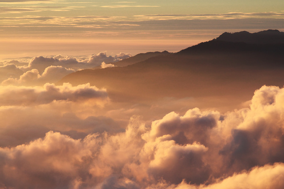 Silhouette of Mountain With Fluffy Clouds during Sunset